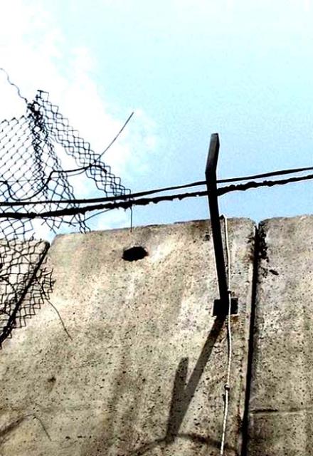 Concrete wall with fences and barbed wire